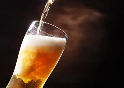 Verre de bière dorée avec mousse blanche