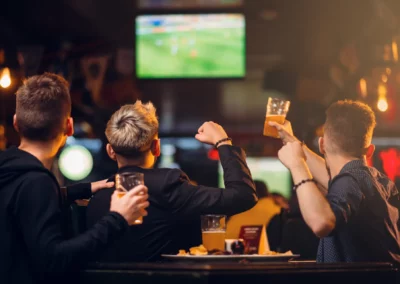 Trois amis regardant un match de football au bar.