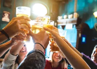 Groupe de personnes trinquant avec des bières.