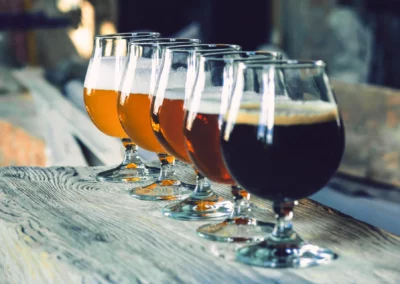 Six verres de bière artisanale sur une table en bois.