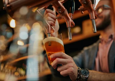 Serveur versant une bière pression dans un verre.